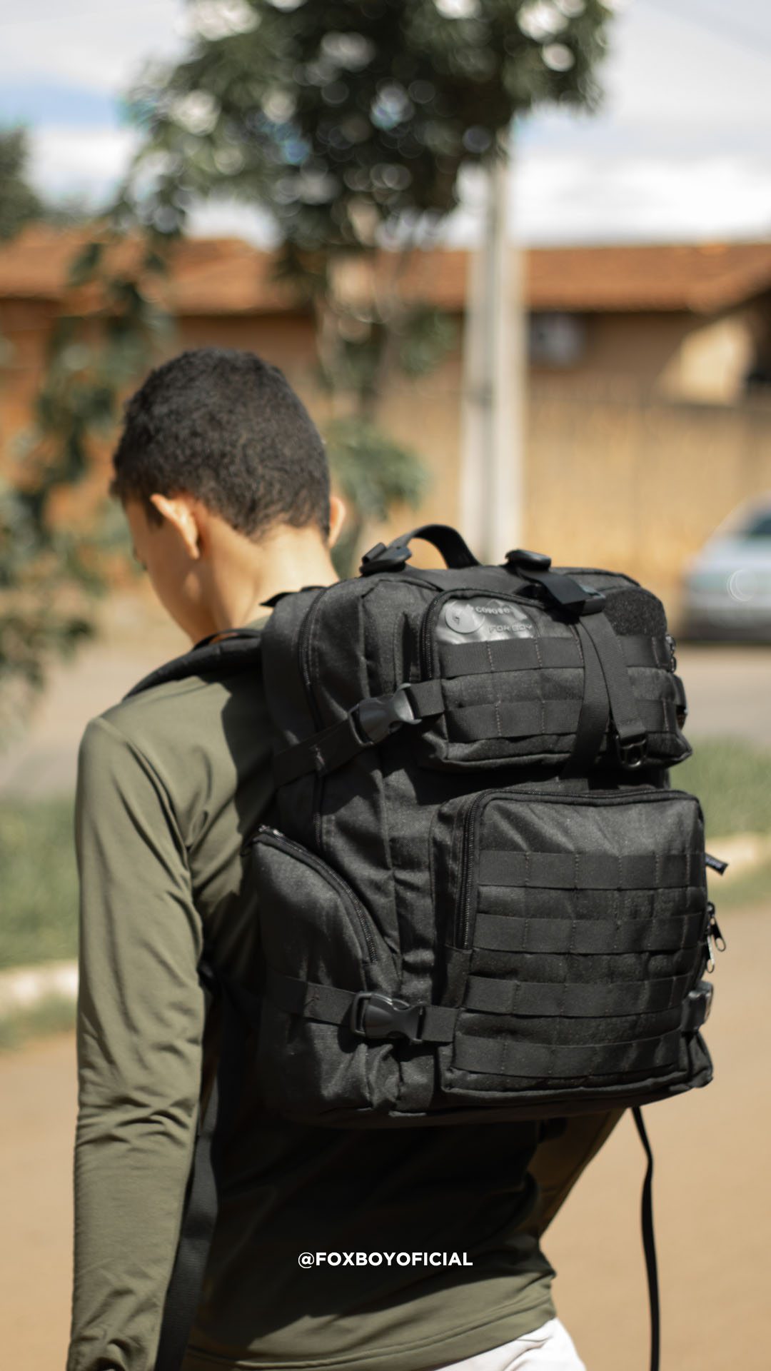 Jovem de costas com mochila tática preta Fox Boy
